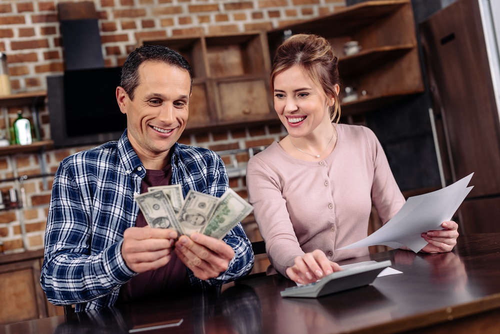 casal sorrindo ao acompanhar suas finanças