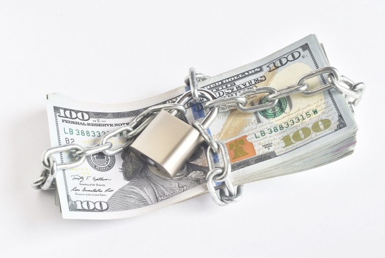 dinheiro acorrentado simbolizando o golpe do empréstimo