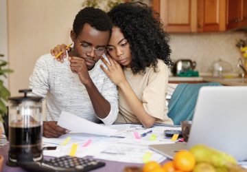 Família jovem africana em crise financeira. Mulher bonita abraçando seu marido