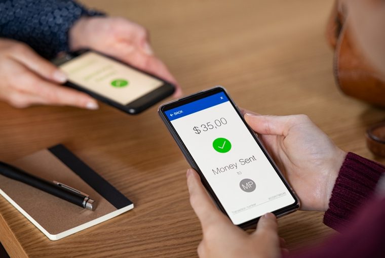 Mulher enviando dinheiro com telefone simulando um pagamento via PIX