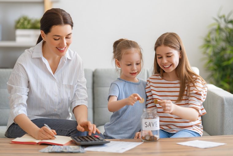 família feliz (mãe e duas filhas) fazendo contas e guardando dinheiro, simbolizando uma vida financeira estável