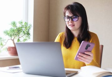 Jovem mulher no computador para consultar restituição do IR