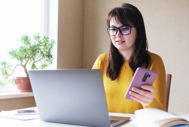 Jovem mulher no computador para consultar restituição do IR