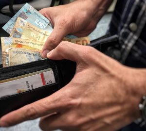 homem colocando dinheiro dentro da carteira, simbolizando o pagamento da restituição do IR 2021