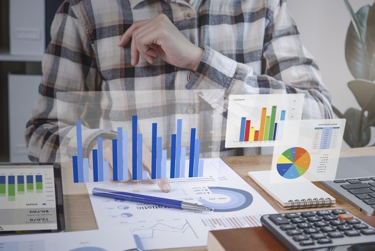 investidor com gráfico de dados em sua mesa, simbolizando osinvestimentos isentos de imposto de renda