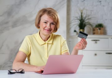 Retrato de uma senhora idosa idosa feliz e positiva com cartão de crédito e pagamento online na loja