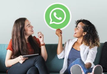 Mulheres jovens mostrando um ícone do whatsapp messenger para simbolizar o uso do WhatsApp Pay