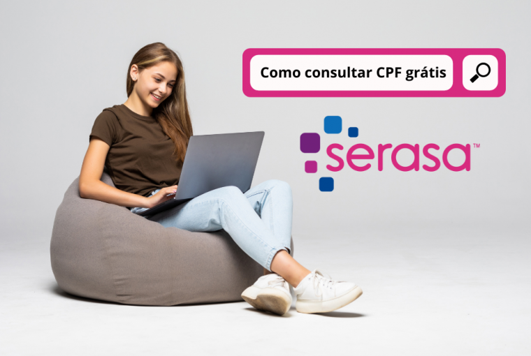 Mulher jovem feliz sentada no chão usando o laptop na parede cinza consultando o CPF grátis pelo Serasa