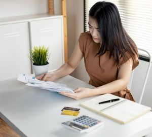 jovem mulher asiática está estressada e pensa demais em dívidas de muitos cartões de crédito e contas