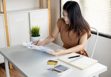 jovem mulher asiática está estressada e pensa demais em dívidas de muitos cartões de crédito e contas