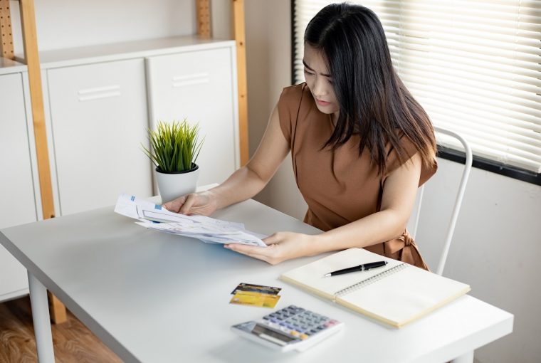 jovem mulher asiática está estressada e pensa demais em dívidas de muitos cartões de crédito e contas