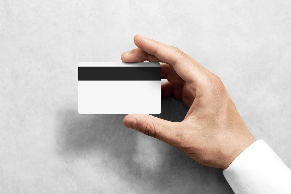 Mão segurando a maquete do cartão de crédito em branco tarja magnética