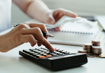 mulheres calculam contas domésticas em casa. usando a calculadora no escritório moderno e verificando o saldo e os custos. mulheres fazendo papelada para pagar impostos vendo se vale mais a pena pagar à vista ou parcelado ou IPVA e IPTU