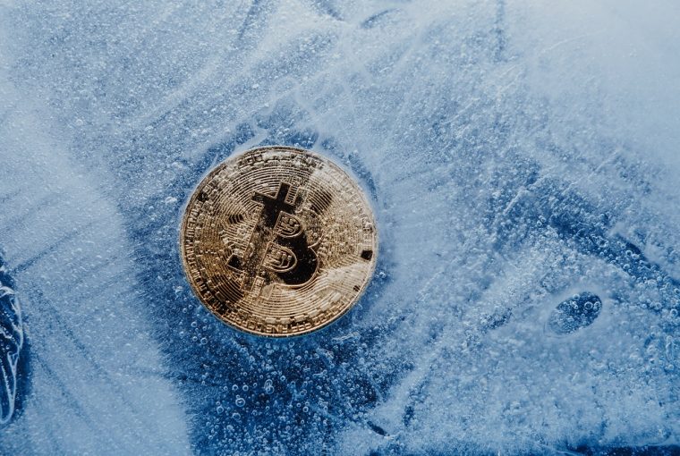 Símbolo dourado bitcoin congelado e coberto com gelo conceito de crise do inverno cripto
