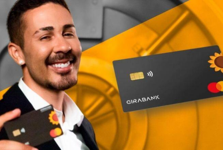 Imagem de Carlinhos Maia sorridente segurança o cartão de seu banco digital, simbolizando se o Cartão do Girabank vale a pena