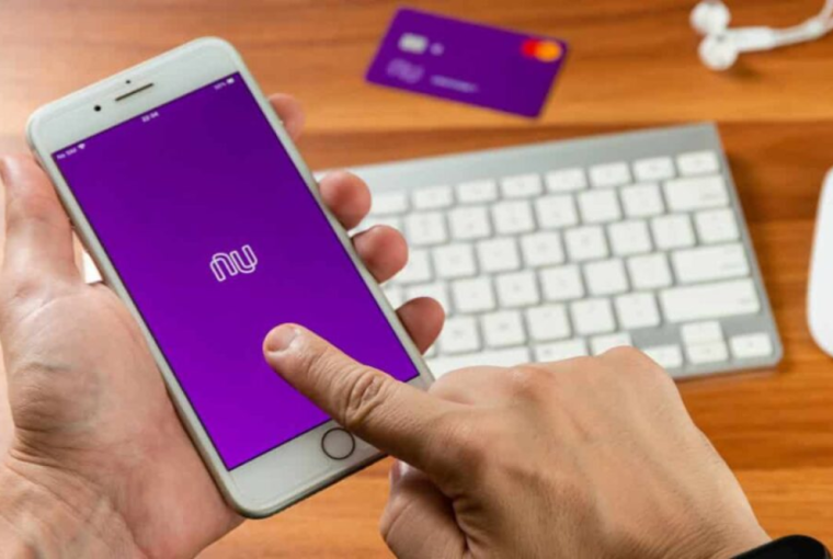 mão mexendo em aplicativo do Nubank no celular, simbolizando a pergunta sobre se o Nubank tem conta conjunta digital?
