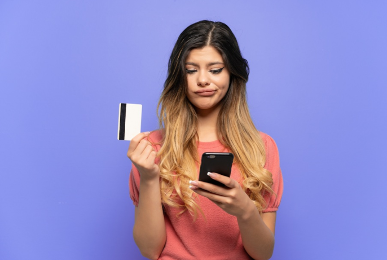 mulher mexendo no celular pesquisando como cancelar compra no cartão de crédito